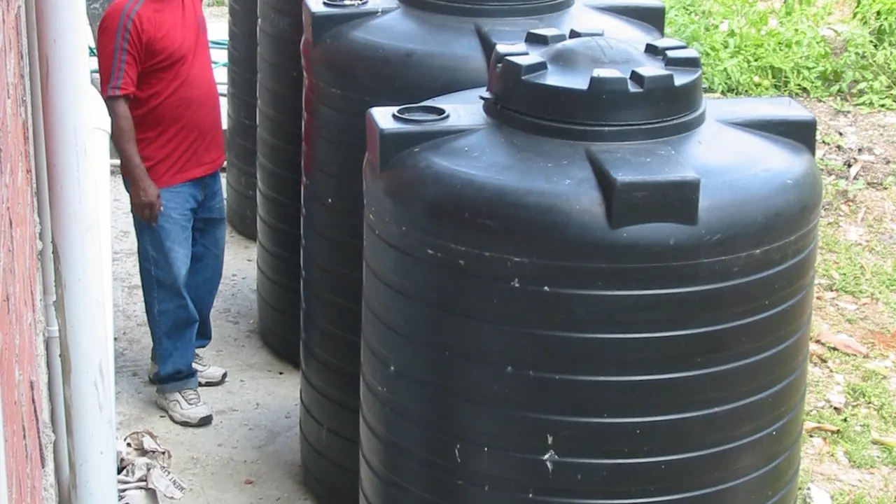 Roof gutters feeding a rainwater storage tank beside a building